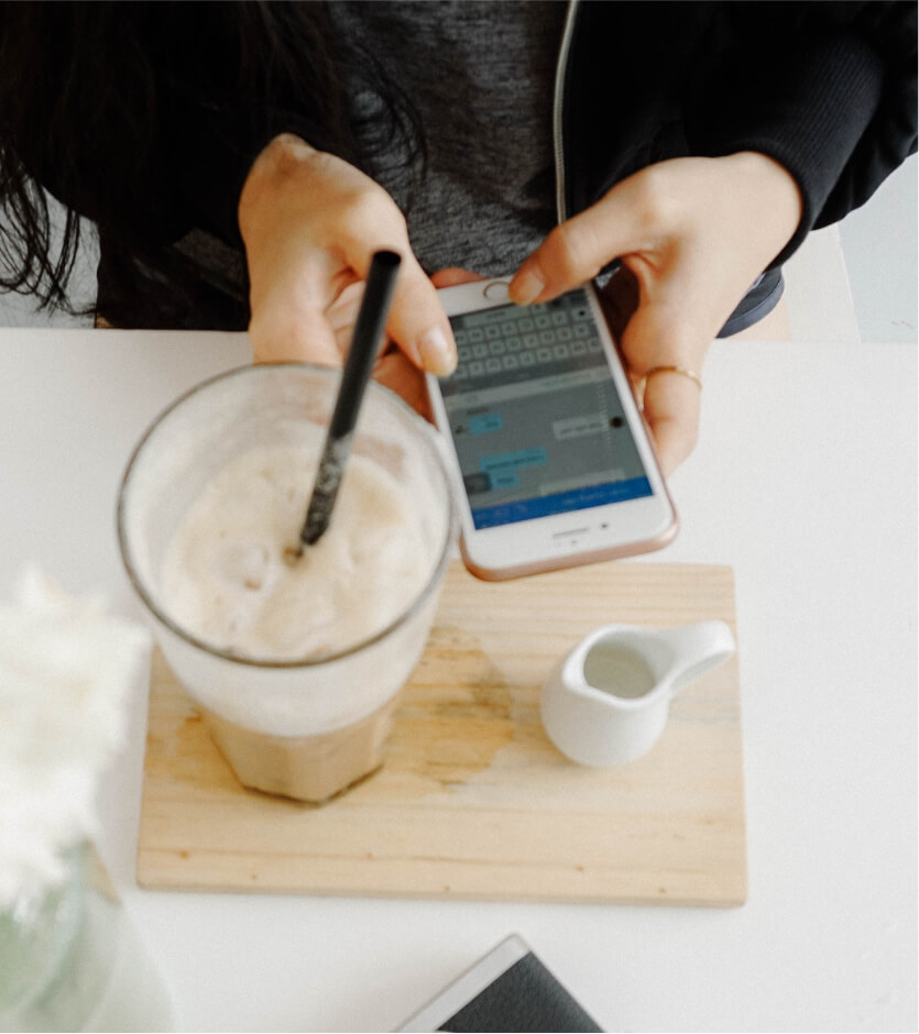 Woman with phone and milkshake